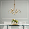 Bella 6 Arm Chandelier in gold finish hanging over dining table,  Synchronicity by Hubbardton Forge