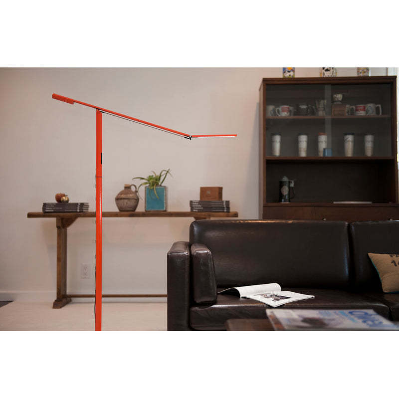 ORANGE EQUO DESK LAMP NEXT TO LEATHER ARM CHAIR