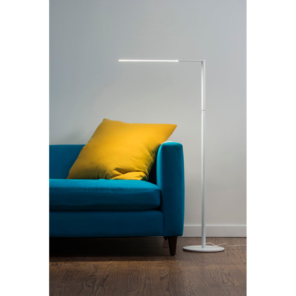 Lady 7 LED floor lamp in matte white next to blue sofa with yellow pillow