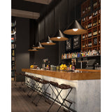 five black and satin gold finished Konos pendants from tech lighting hanging over a bar