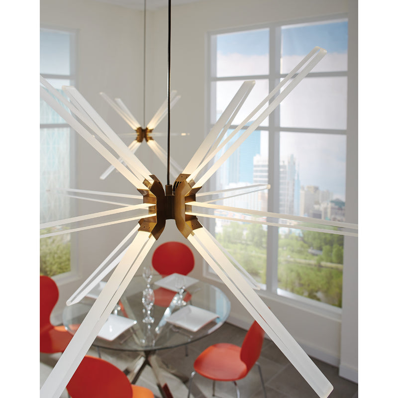 Photon pendant in aged brass hanging over glass dining table