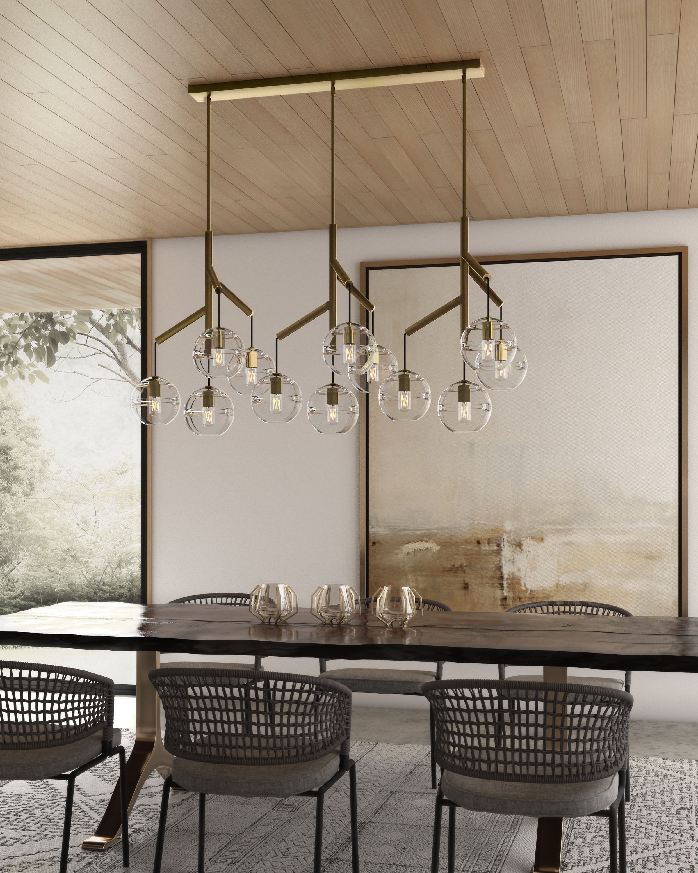 sedona triple chandelier in aged brass with clear glass hanging over a dining table